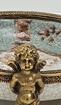 aardewerk rond schaaltje gedragen door 3 messing engeltjes met de handen op de rug
