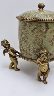 Aardewerk pot met messing parelrand langs deksel en messing knopje gedragen door 4 massief messing engeltjes
