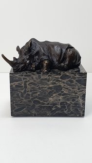 Bronzen neushoorn op marmer sokkel liggend