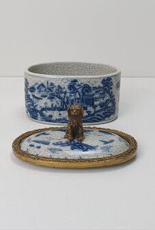 Delfts blauw ovaal box met messing rand langs de deksel en als handvat zittend hond in brons messing