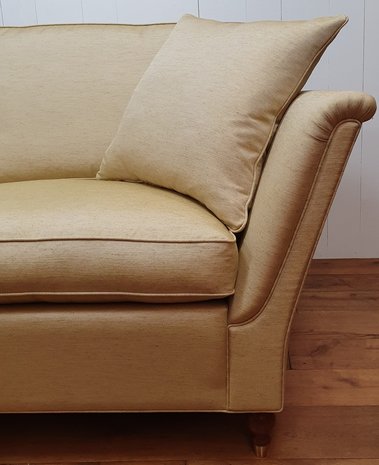 Engelse sofa met strakke uitlopende armen en bolpoot met messing wiel