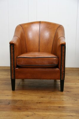 Schapenleren club fauteuil met zwarte accenten en nagels