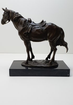 Bronzen beeld van paard met zadel op marmer